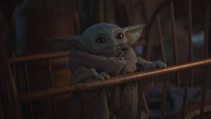 Cute Baby Yoda On Crib Wallpaper