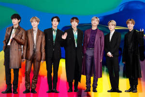Cute Bts Group On Stage With Rainbow Backdrop Wallpaper