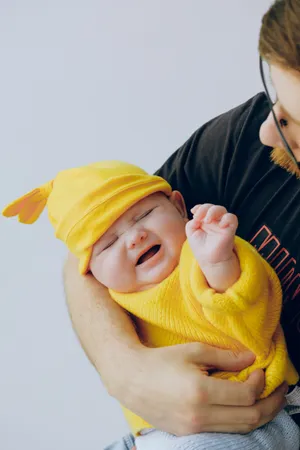 Cute Crying Baby In Yellow Outfit Wallpaper