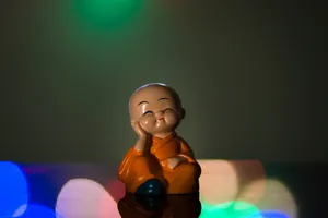 Cute Doll Monk On Table Wallpaper