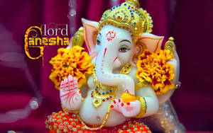Cute Ganesh With Yellow Flowers Wallpaper