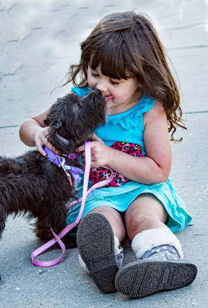 Cute Girl Licking A Puppy Wallpaper