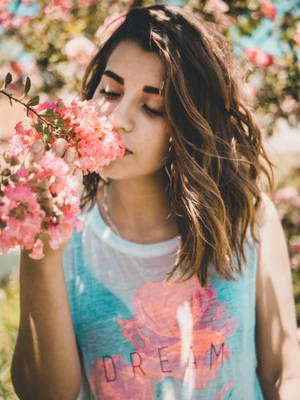Cute Girl Sniffing Pink Flowers Wallpaper