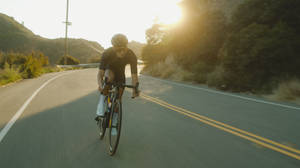 Cycling On Winding Road Wallpaper