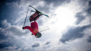 Daredevil Ski Jumper Performing A High-flying Backflip Wallpaper