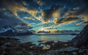 Dark Blue Clouds Over Rocky Coastline Wallpaper