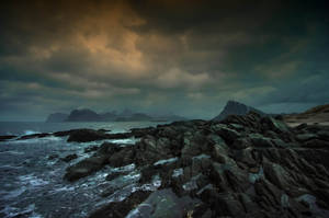 Dark Blue Clouds Over Rocky Seas Wallpaper