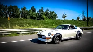 Datsun Car On Scenic Highway Wallpaper