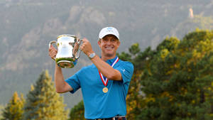 David Toms Celebrating His Victory With A Medal And Trophy. Wallpaper