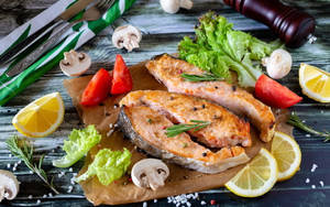 Delectable Dish Of Fresh Salmon Served With Vegetables And Garnish Wallpaper