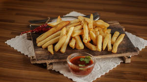 Delicious Golden French Fries On A Rustic Wooden Platter Wallpaper