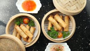 Delicious Steaming Basket Of Egg Rolls Wallpaper
