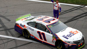 Denny Hamlin Poses Next To His Racing Car Wallpaper