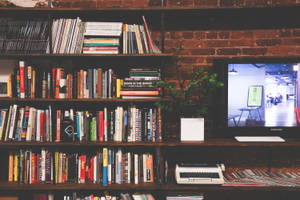 Desk With Fiction And Reference Books Wallpaper