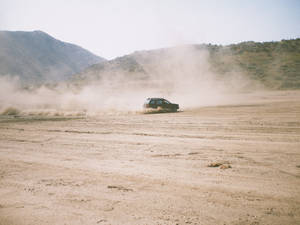 Dirt Rally Car In Desert Route Wallpaper