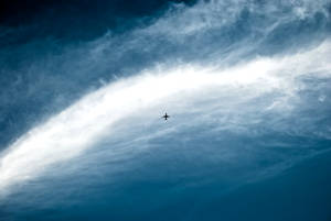 Distant Plane In Vast Sky Wallpaper