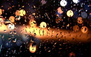 Dripping Raindrops On Glass Pane With Bokeh Wallpaper