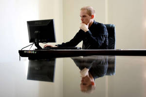 Dynamic Entrepreneur Crafting Success In His Office Wallpaper