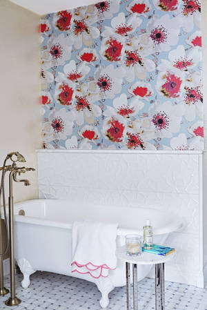 Elegance In Simplicity: A Pristine White Bathtub Against Flowery Wallpaper Wallpaper