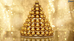 Elegant Pyramid Of Ferrero Rocher Chocolates Wrapped In Gold Foil Wallpaper
