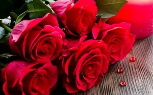Elegant Red Roses Adorning A Laptop Wallpaper