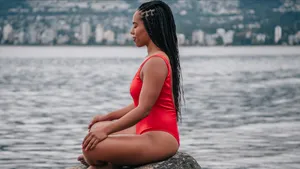 Elegant Swimsuit Model Meditating On The Beach Wallpaper