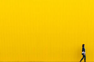 Embracing Boldness - Girl Against Yellow Wall Wallpaper