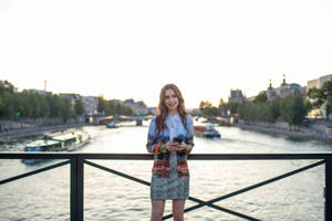 Emily In Paris Standing On A Bridge Wallpaper