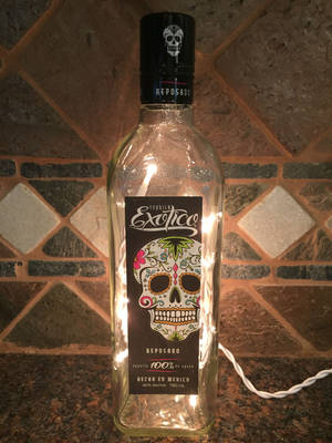 Empty Exotico Tequila Bottle With Light Wallpaper