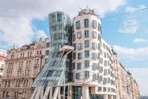 Enchanting View Of The Dancing House In Prague Under The Cloudy Blue Sky Wallpaper