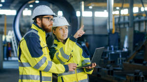 Engineers Working And Holding Laptop Wallpaper