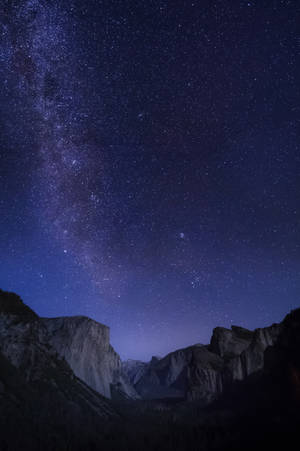 Enjoy A Tranquil Evening At The Foot Of A Majestic Night Mountain Wallpaper