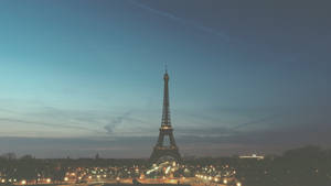 Enjoy The Charm Of The City Of Lights At Night Wallpaper