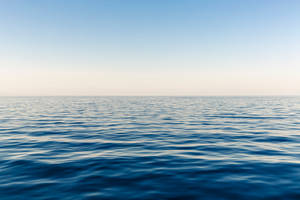 Enjoy The Magical View Of A Never Ending Horizon Of Blue Ocean Water. Wallpaper