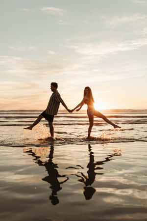 Evening Surf Couple At Beach Wallpaper