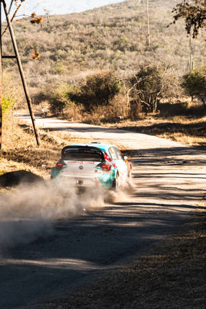 Exhilarating Speed - Dirt Rally Car Blazing Through A Trail Wallpaper