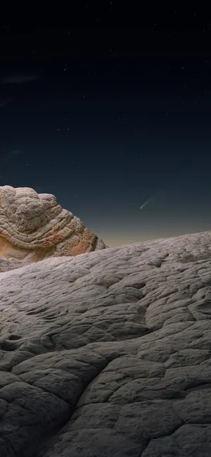 Extravagant Iphone 12 Pro Placed On Rocky Surface Wallpaper