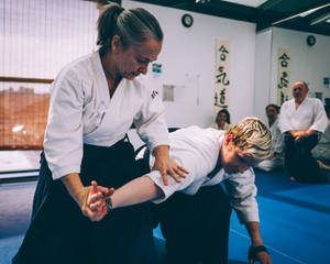 Female Aikidoka Performing Nikyo Aikido Technique Wallpaper