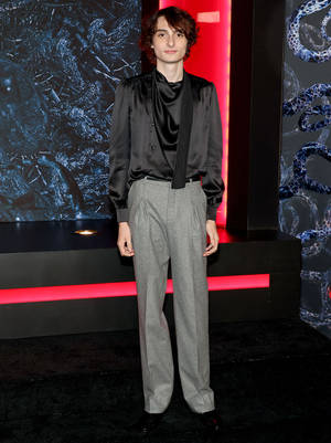 Finn Wolfhard With Gray Pants Wallpaper