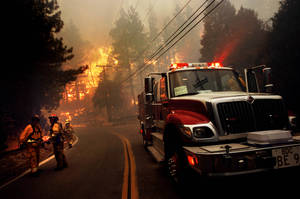 Fireman Near A Firetruck In A Forest Fire Wallpaper