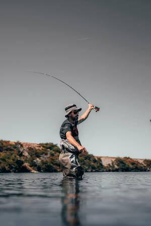 Fishing For Bass With A Spoon Lure In A Serene Lake. Wallpaper