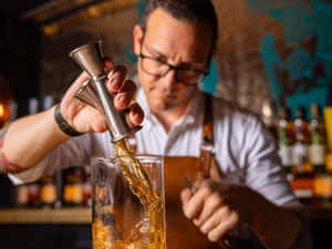 Focused Bartender Pouring Drink Wallpaper