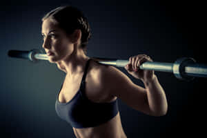 Focused Female Athlete Barbell Workout Wallpaper