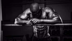 Focused Muscular Man Resting During Workout Wallpaper
