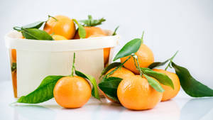 Fresh Clementine Citrus Fruits In A White Basket Wallpaper