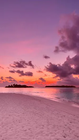 Get A Mesmerizing View Of A Pink Sunset Right On Your Iphone. Wallpaper