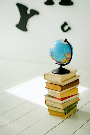 Globe Placed Over The Books Wallpaper