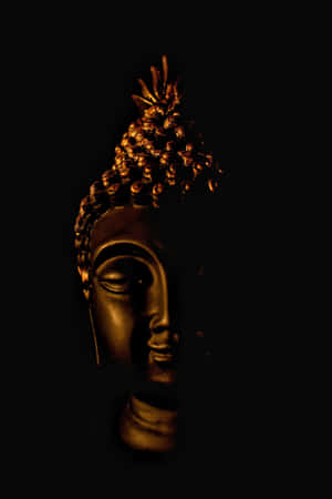 Golden Buddha Statuein Darkness Wallpaper