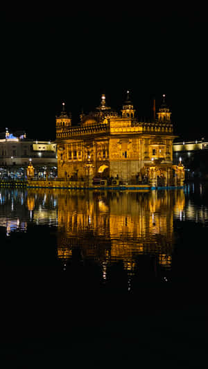 Golden Temple Lit Up At Night Wallpaper