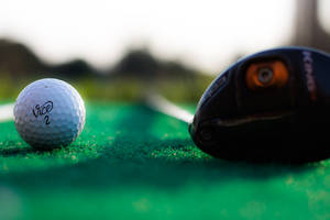 Golf Ball And Club Lying On Golf Course Wallpaper